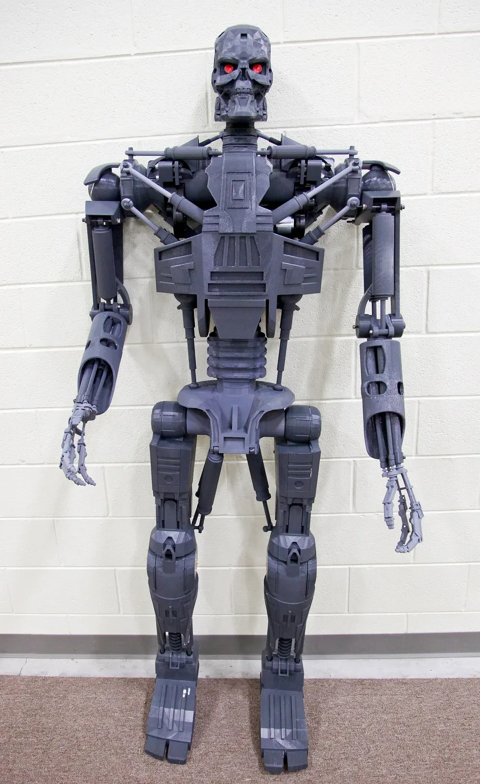 Close-up photograph of an additive manufacturing 3D printer in operation, showing the printing head and layered material being deposited during the build process.