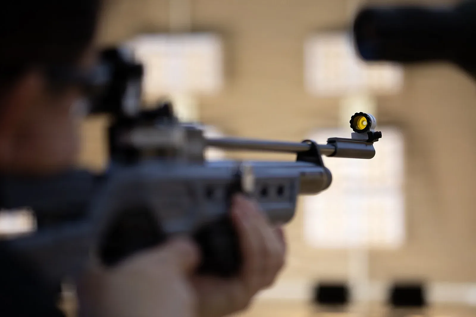 JROTC cadets in prone shooting position with air rifles at a marksmanship competition, demonstrating proper form and stance at a competitive event.