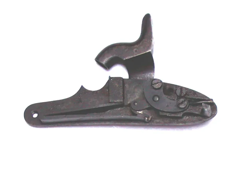 Close-up view of a percussion lock mechanism showing the hammer, nipple, and firing components of a 19th-century firearm