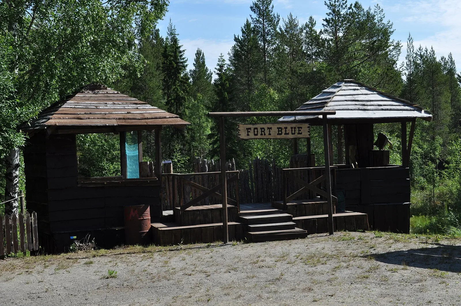 A competitor actively shooting during a cowboy action shooting stage, demonstrating the sport's dynamic shooting scenario with period firearms.