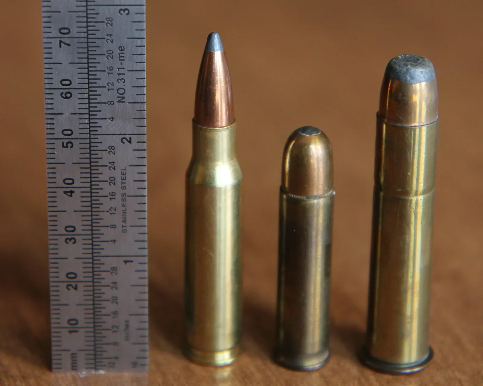 Three rifle cartridges displayed side by side showing .401 Winchester Self-Loading Rifle, .45-70, and .308 Winchester ammunition for size comparison