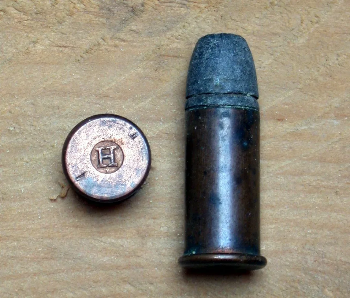 A .44 Henry rimfire cartridge displayed against a plain background, showing the characteristic flat-nosed bullet and brass case with visible rim.