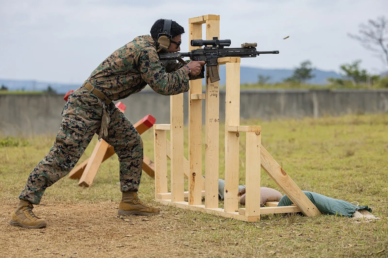 U.S. Marines in prone shooting position during rifle competition practice, demonstrating proper form and technique with rifles mounted on rests.