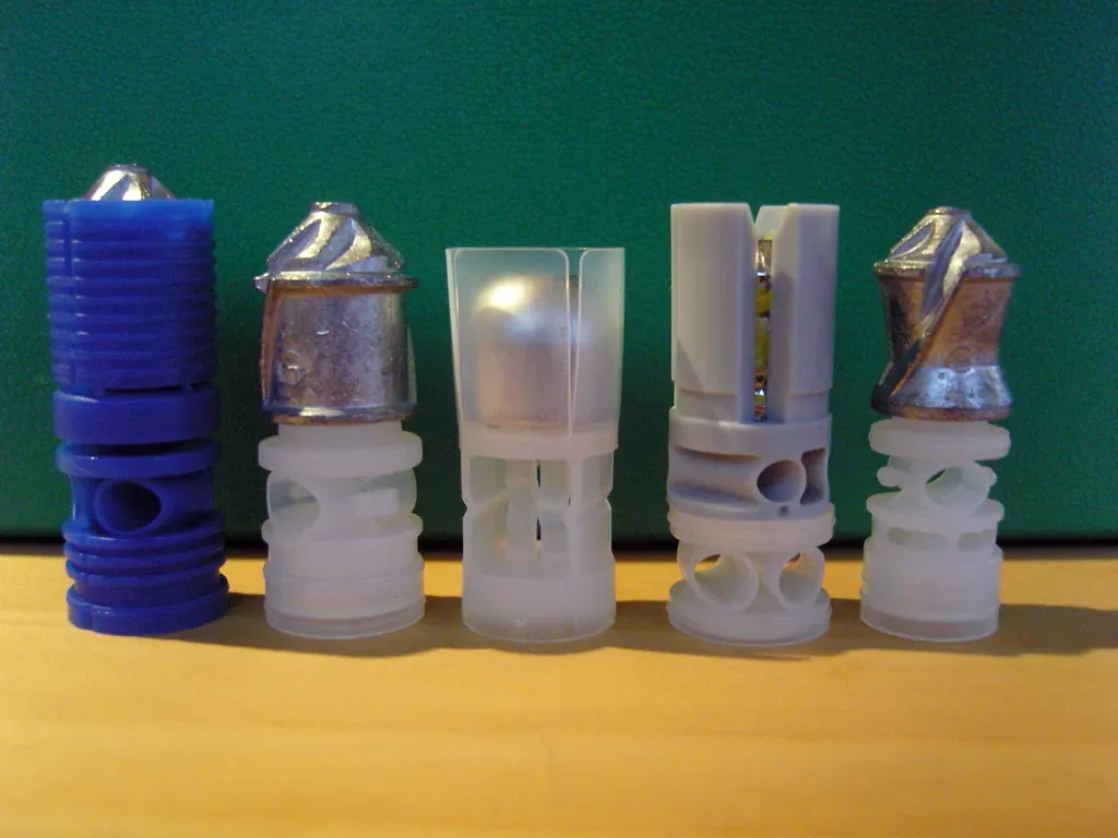 Four shotgun slugs arranged in a row showing different weights and designs: 12 gauge 7/8 oz Blue Force slug, 12 gauge 1-1/8 oz slug, and two additional slug variants, demonstrating variation in ammunition types and masses used with shotguns.