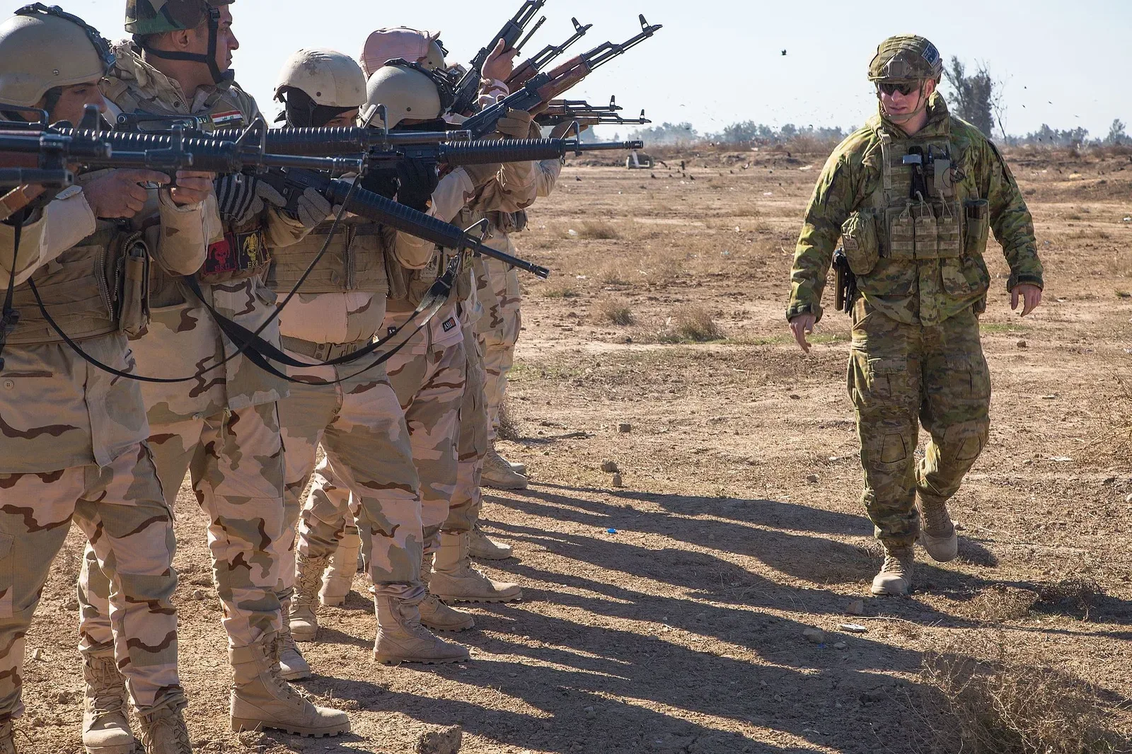 A military trainer instructing Iraqi security forces soldiers on weapons safety procedures with rifles at Camp Taji, Iraq.
