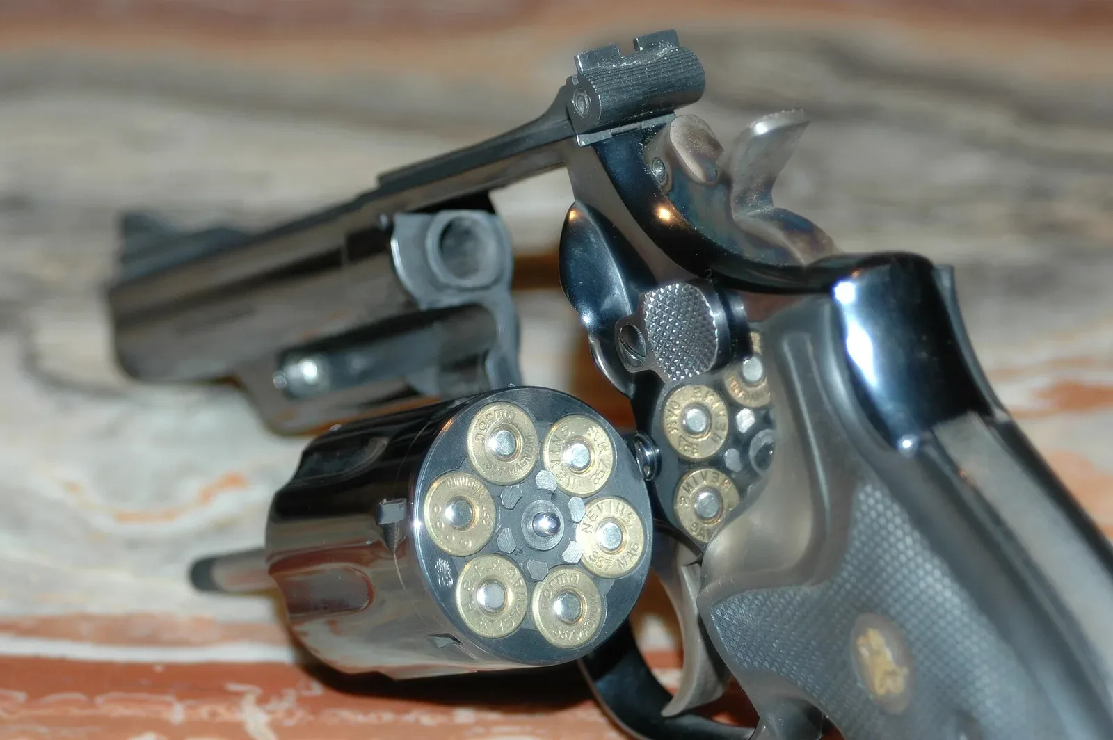 Smith & Wesson Model 19 revolver displayed with its cylinder open, showing the internal mechanism and six chambers.