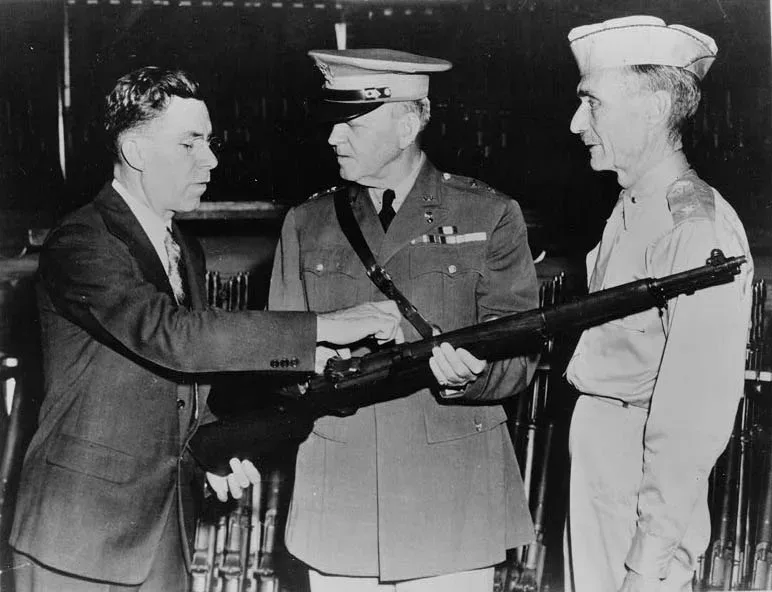 John Garand pointing out features of the M1 Garand rifle to senior Army personnel