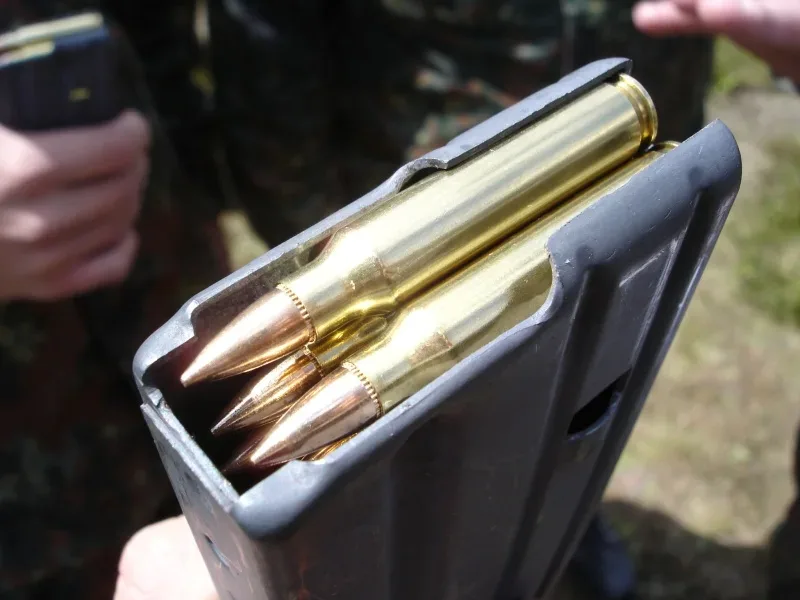 A single 5.56×45mm NATO cartridge loaded in an M16 rifle magazine