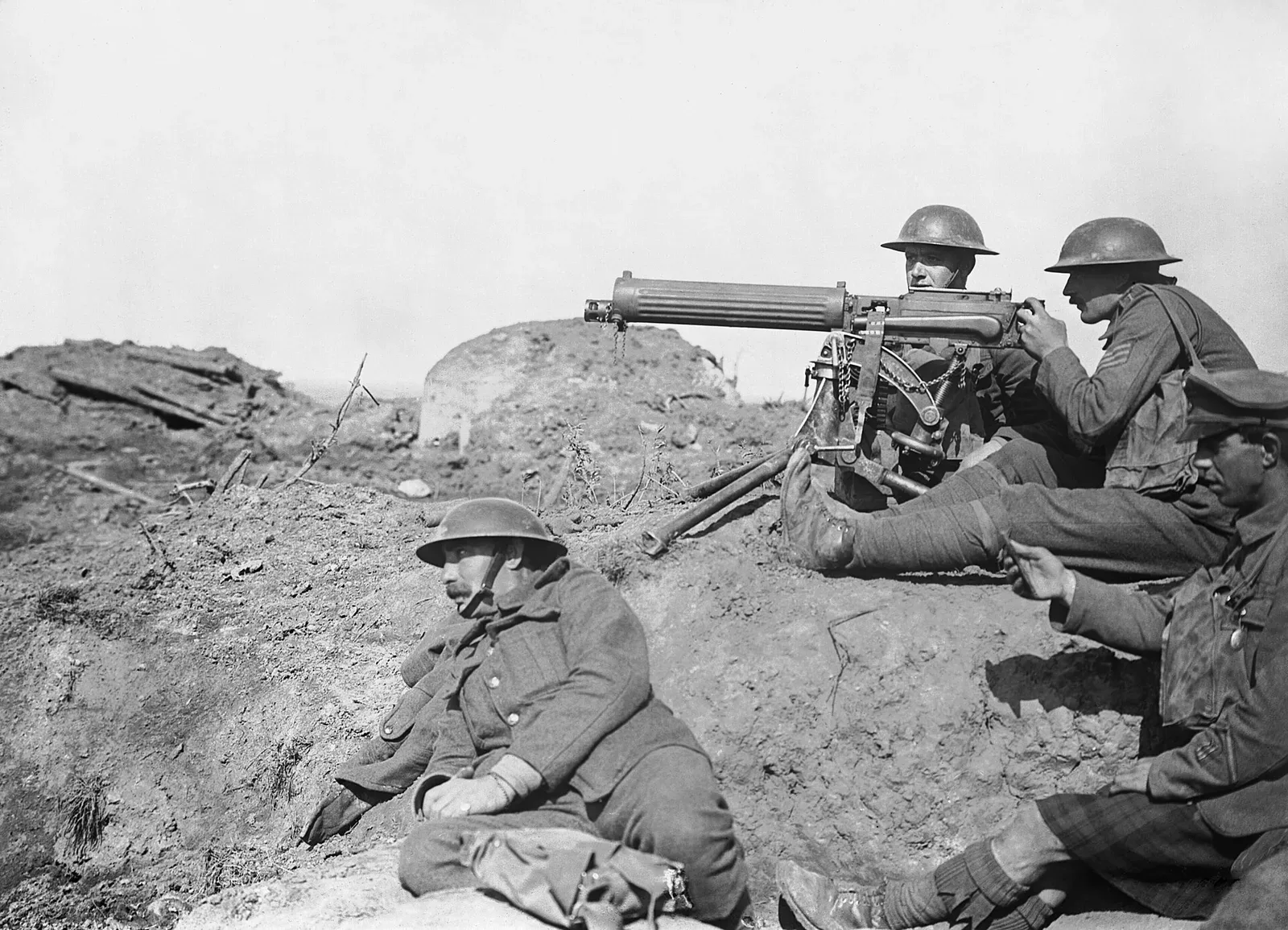 A Vickers machine gun in operational use during the Battle of Passchendaele in September 1917, mounted on a tripod with soldiers nearby in a trench setting.