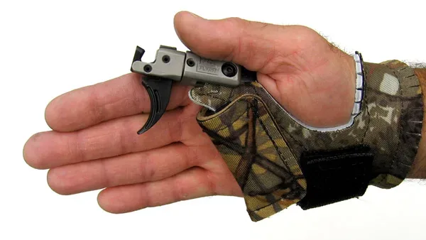 A mechanical release aid device used in archery, showing the trigger mechanism and finger loops for drawing the bowstring.