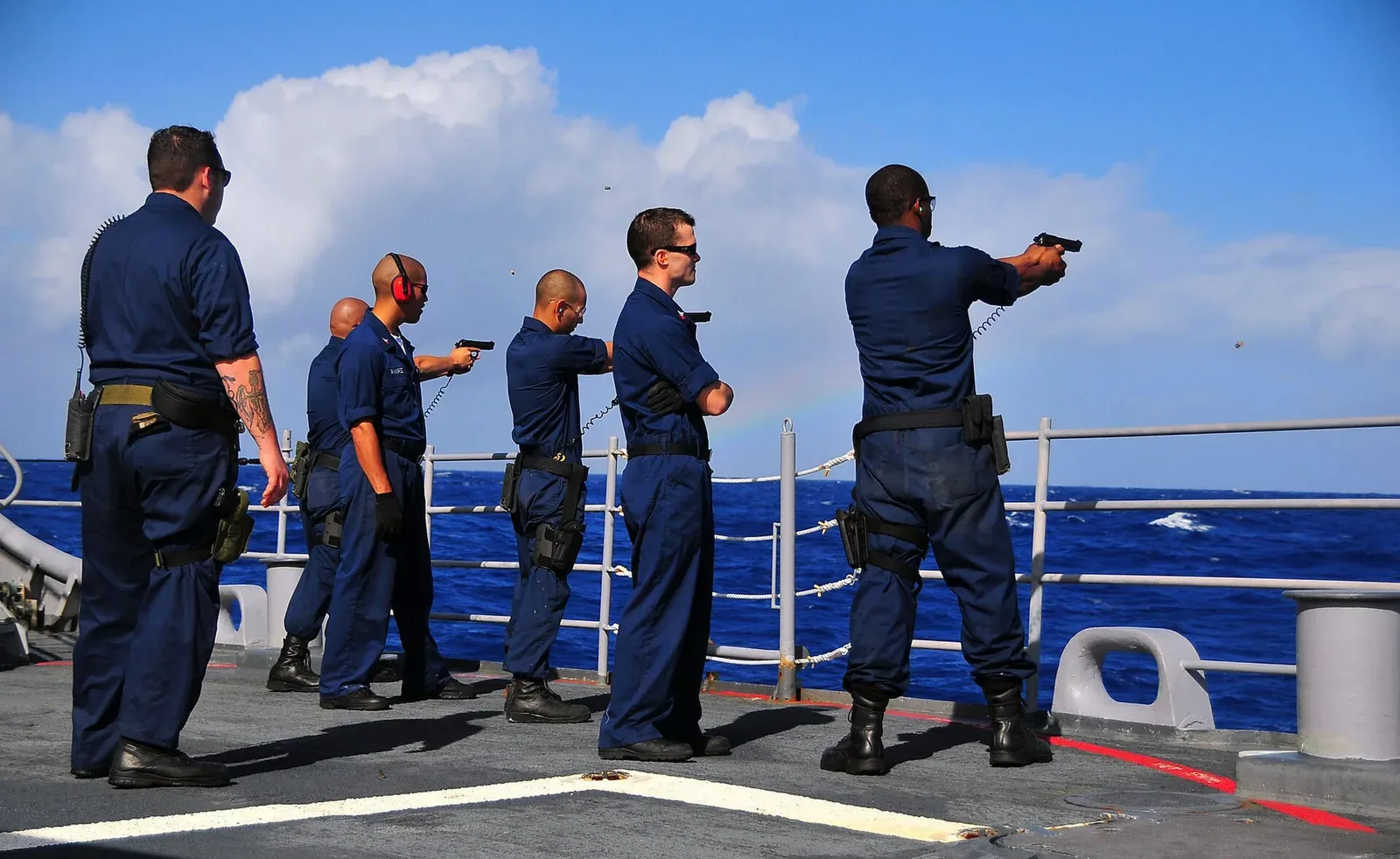 U.S. Navy sailors firing Beretta M9 9mm pistols during live-fire training exercise