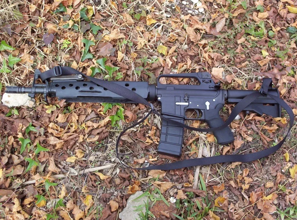 Bushmaster Dissipator Model XM-15 rifle with black polymer furniture, flat-top receiver, and aftermarket handguards, shown in right-side profile against a neutral background.