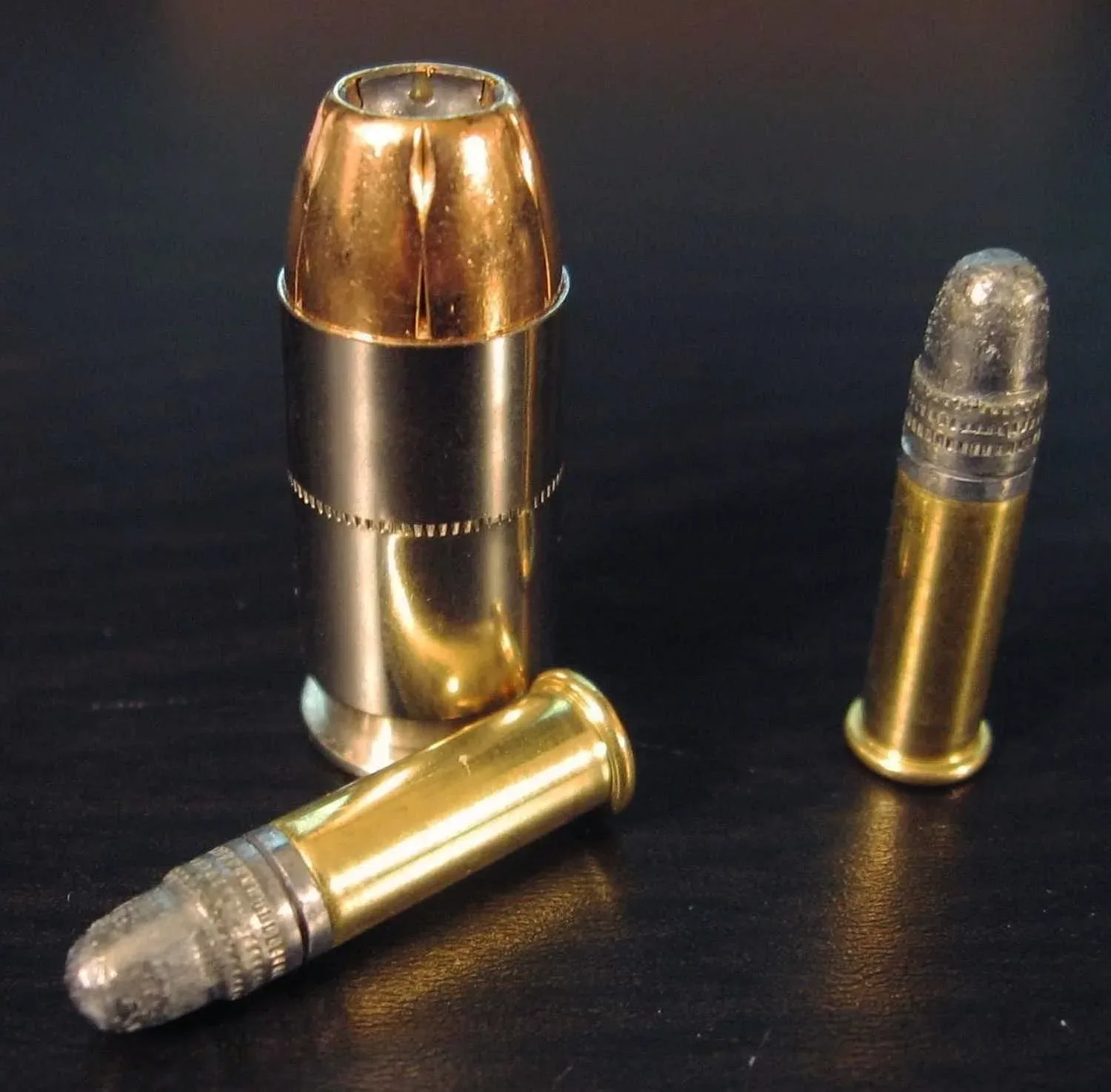 A single round of .45 ACP Federal HST 230gr hollow-point cartridge displayed next to two rounds of CCI ammunition