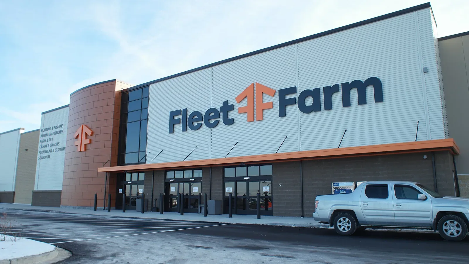 Exterior view of a Fleet Farm retail store in West Bend, Wisconsin, showing the large warehouse-style building with prominent signage and parking lot.