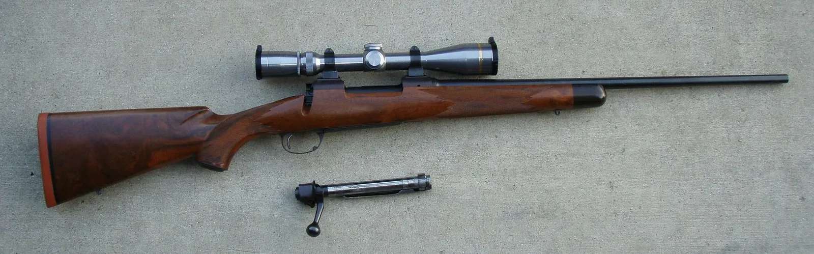 A Kimber rifle chambered in .270 Winchester, featuring a modern bolt-action design with a wooden stock and scope mounted on the receiver.
