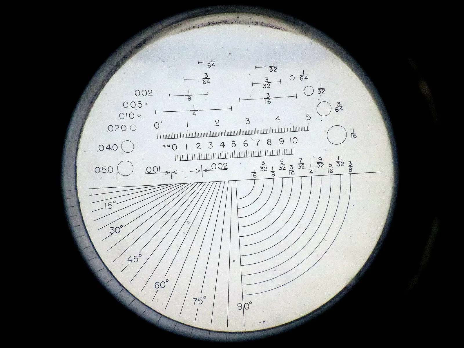 Close-up view of a reticle pattern from a Bell & Howell Pocket Comparator optical instrument, showing crosshair and measurement markings