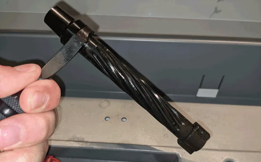 Close-up of an oiled Kelbly rifle action bolt showing the bolt handle and lugs