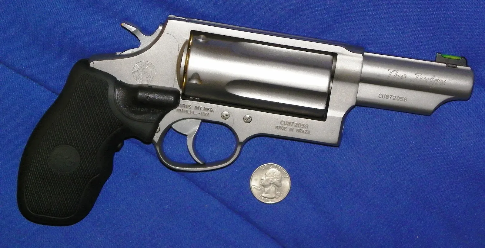 Taurus Judge Magnum revolver in .45 Long Colt/.410 Bore caliber with laser grip attachment, shown from the side.