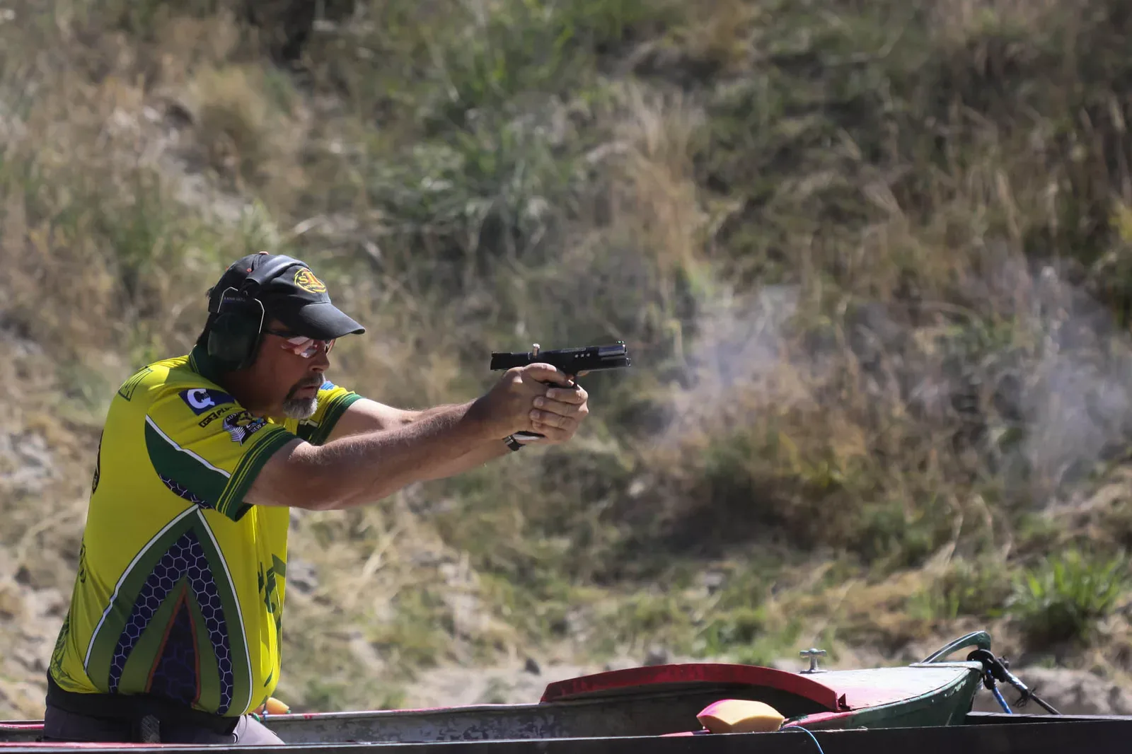 A Standard division competitor shooting at the 2013 IPSC Australasian Handgun Championship, demonstrating practical shooting stance and technique during competition.