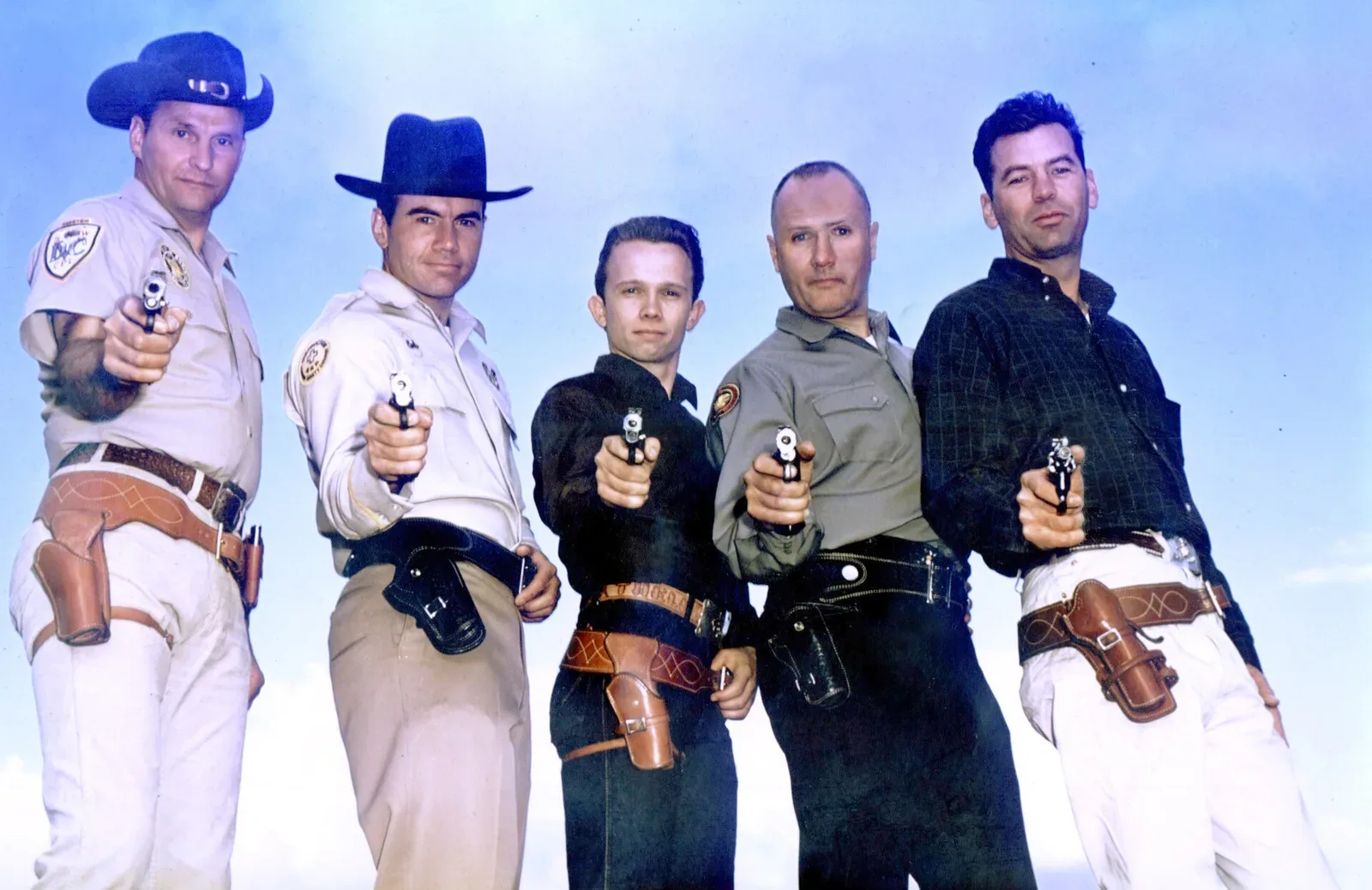 Five shooters identified as Combat Masters demonstrating practical shooting positions and techniques during competition