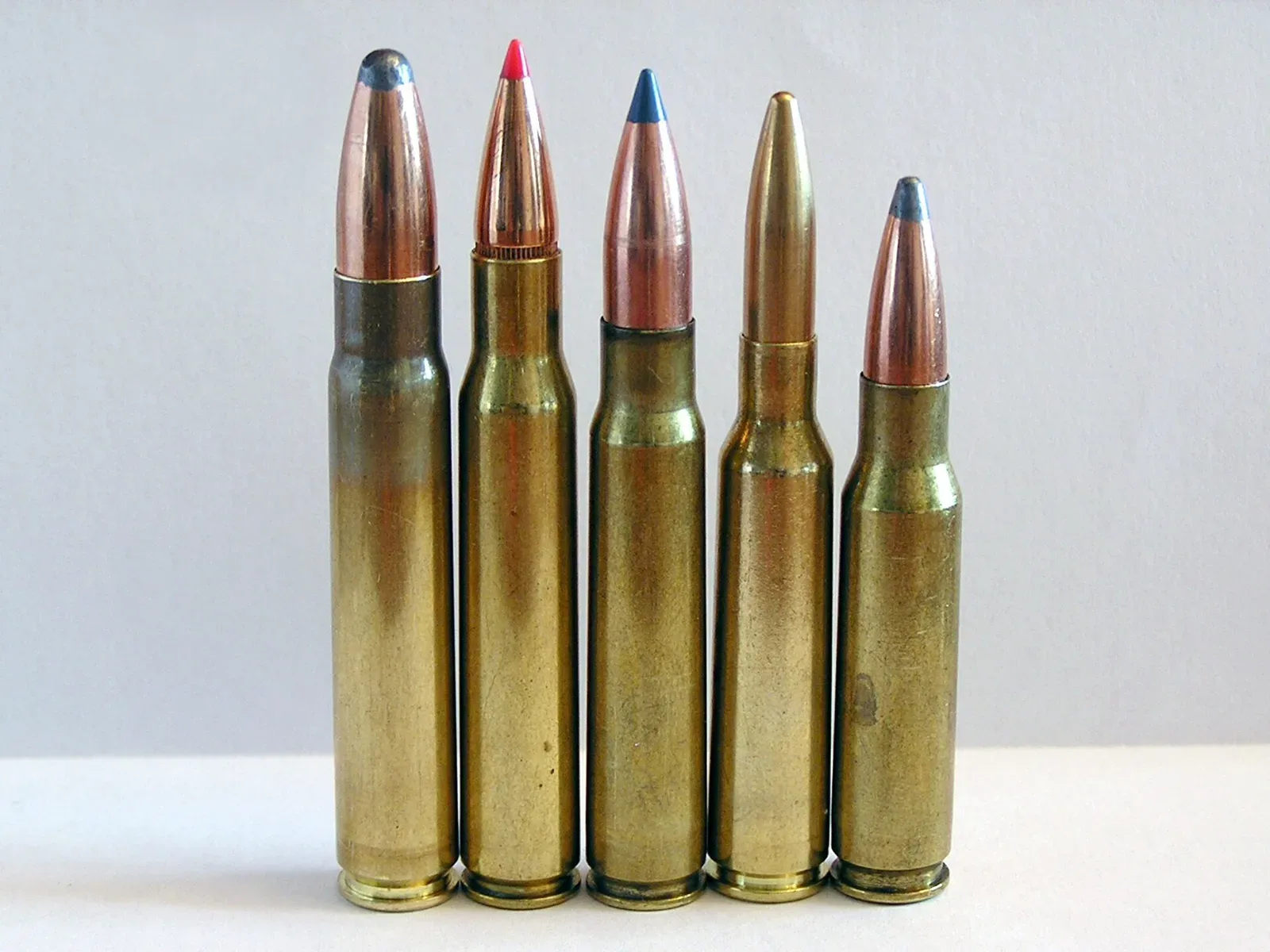 Five rifle cartridges arranged in a line for comparison: 9.3×62, .30-06 Springfield, 8×57 IS, 6.5×55, and .308 Winchester, showing relative sizes and case dimensions.