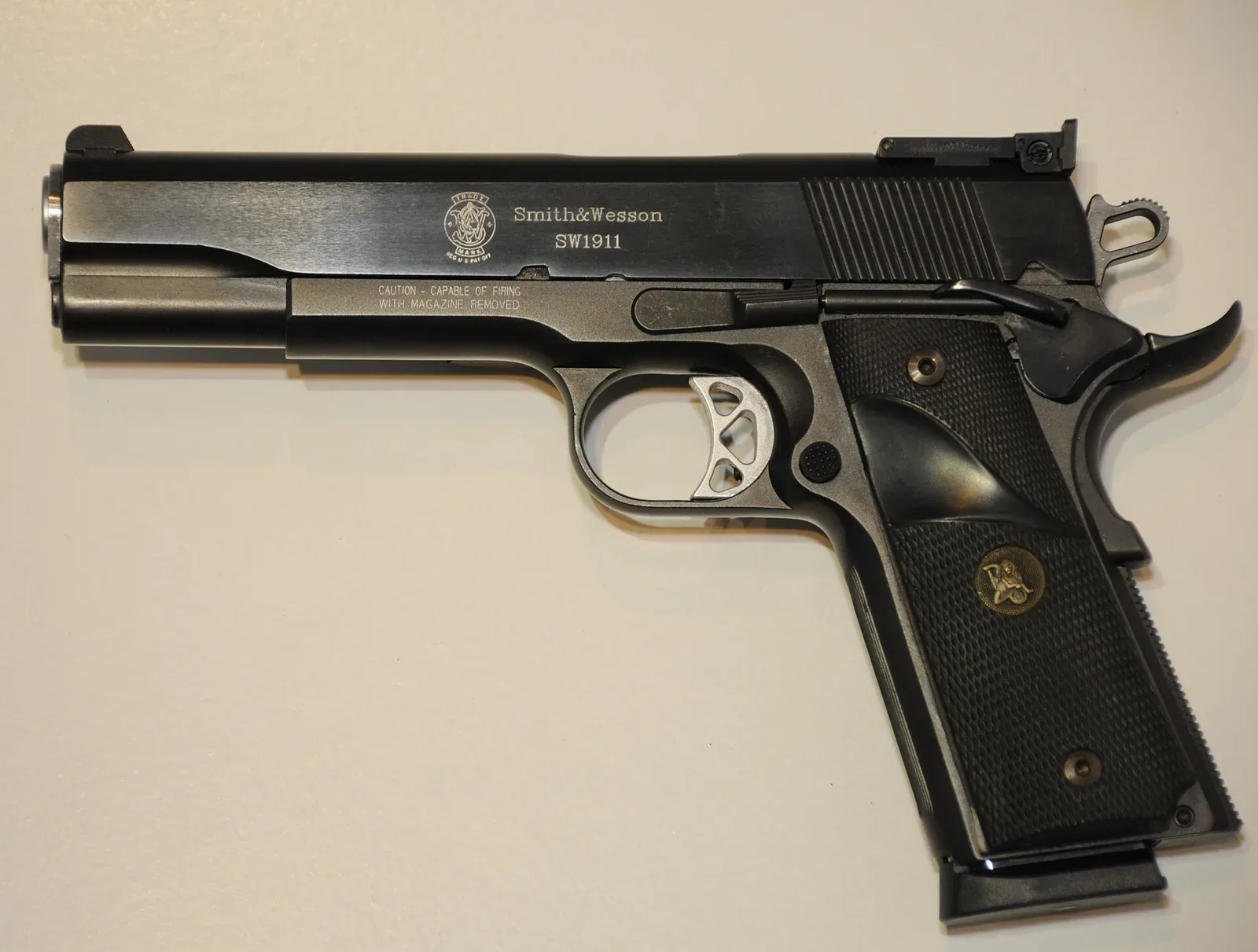 Smith & Wesson SW1911 semi-automatic pistol with Pachmayr grip panels installed, shown in profile against a neutral background