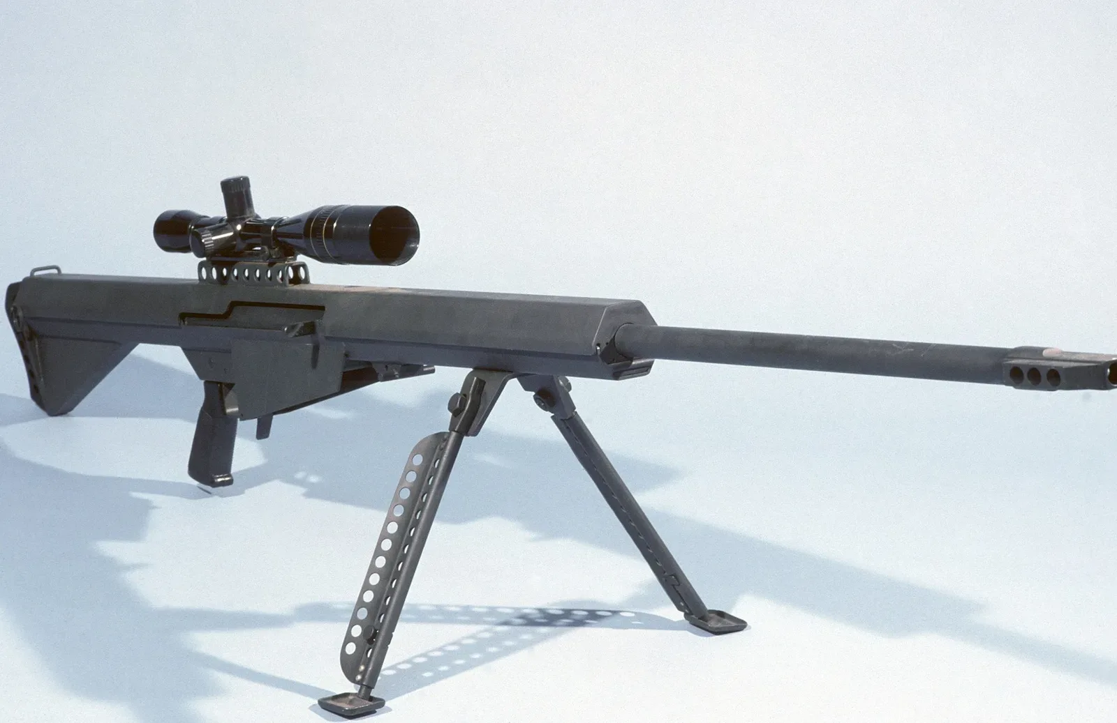 A Barrett M82 light .50-caliber sniper rifle mounted with a scope, shown from a side profile view.