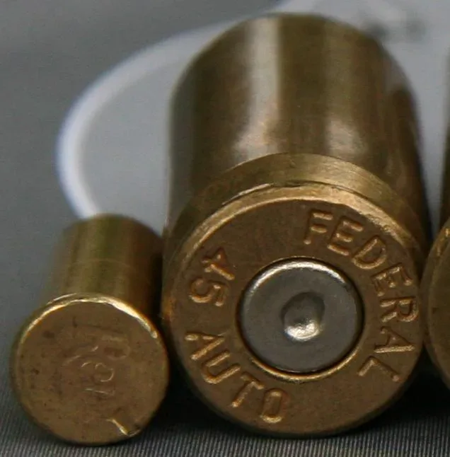 Fired rimfire cartridge casing on the left and fired centerfire cartridge casing on the right, showing the difference in primer pocket design and placement