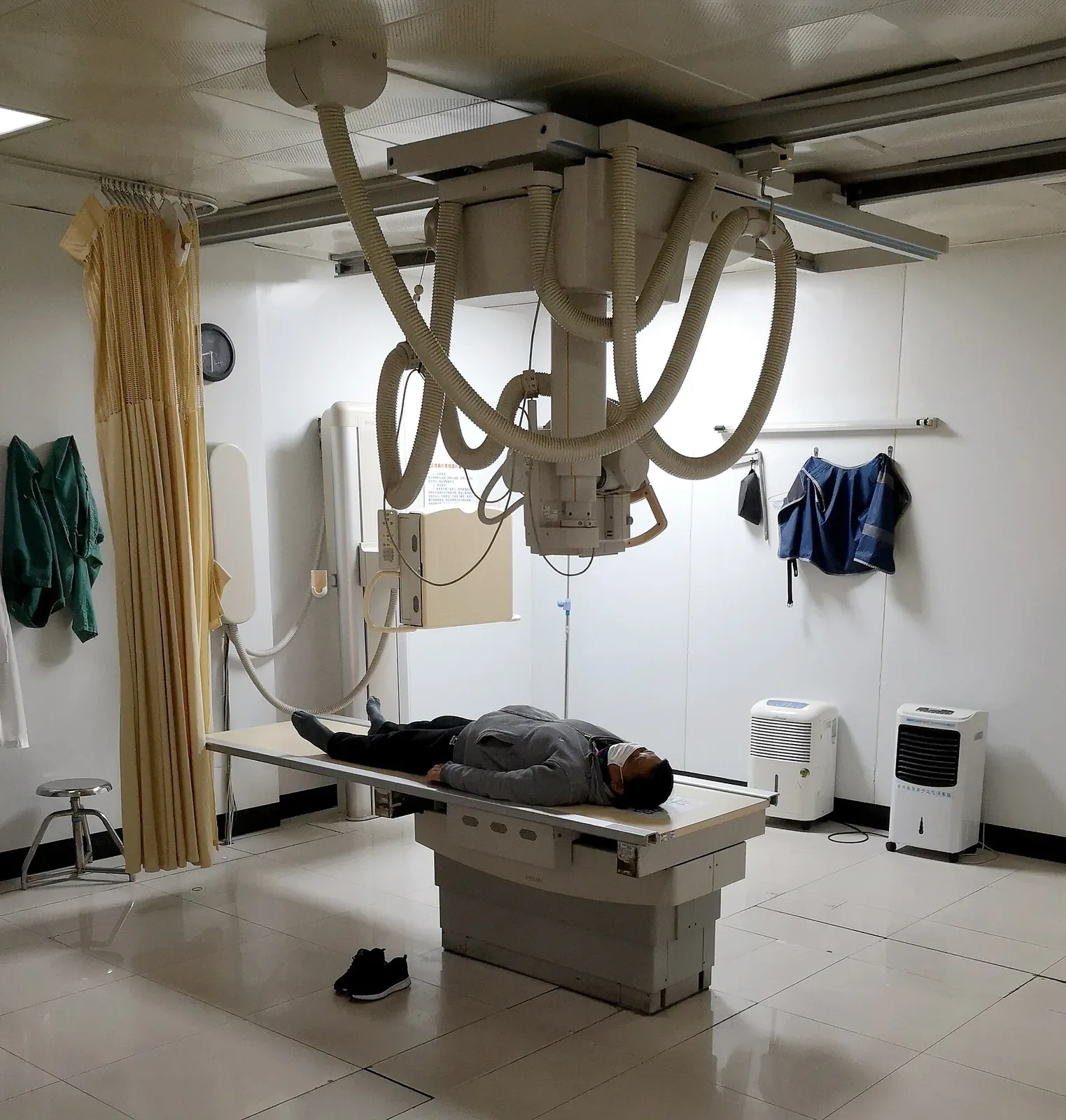 Patient undergoing X-ray examination in a hospital radiology room with a Philips DigitalDiagnost Digital Radiography System