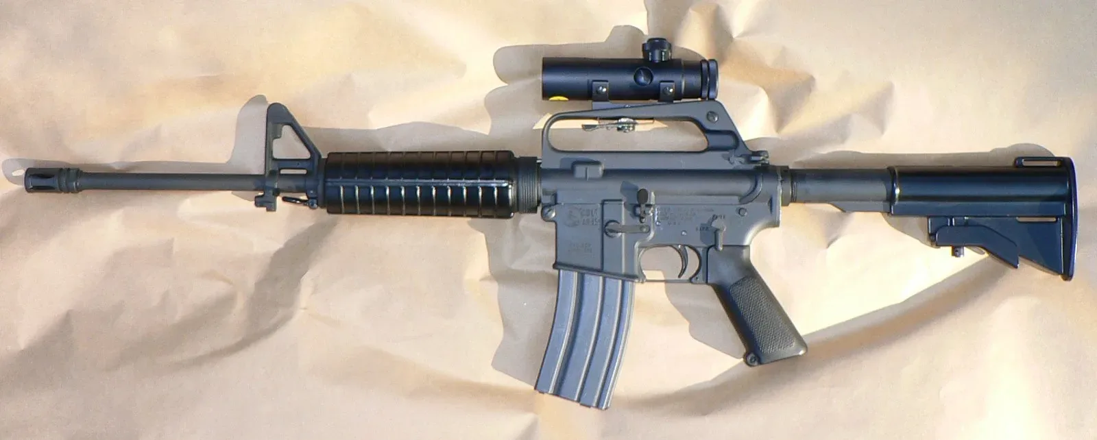 Colt AR-15 Sporter SP1 Carbine, a semiautomatic rifle with pistol grip, collapsible stock, and upper receiver mounted rail system.