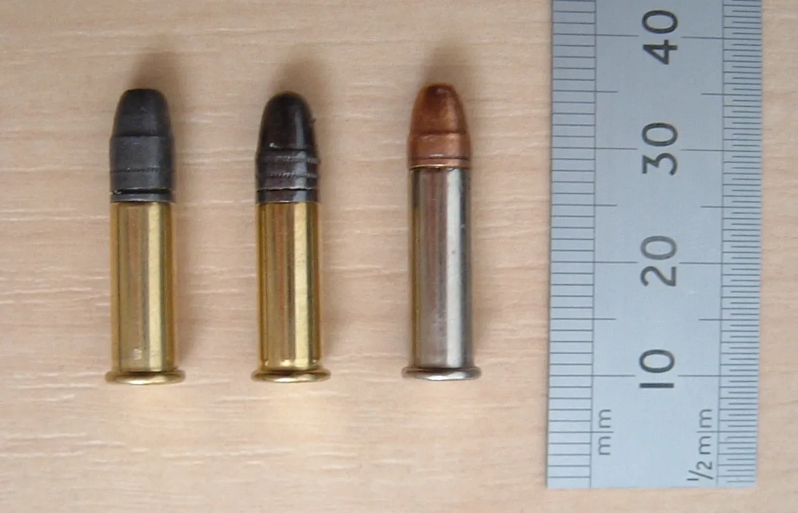 Close-up photograph of a .22 LR rimfire cartridge showing the complete round with bullet, case, and primer